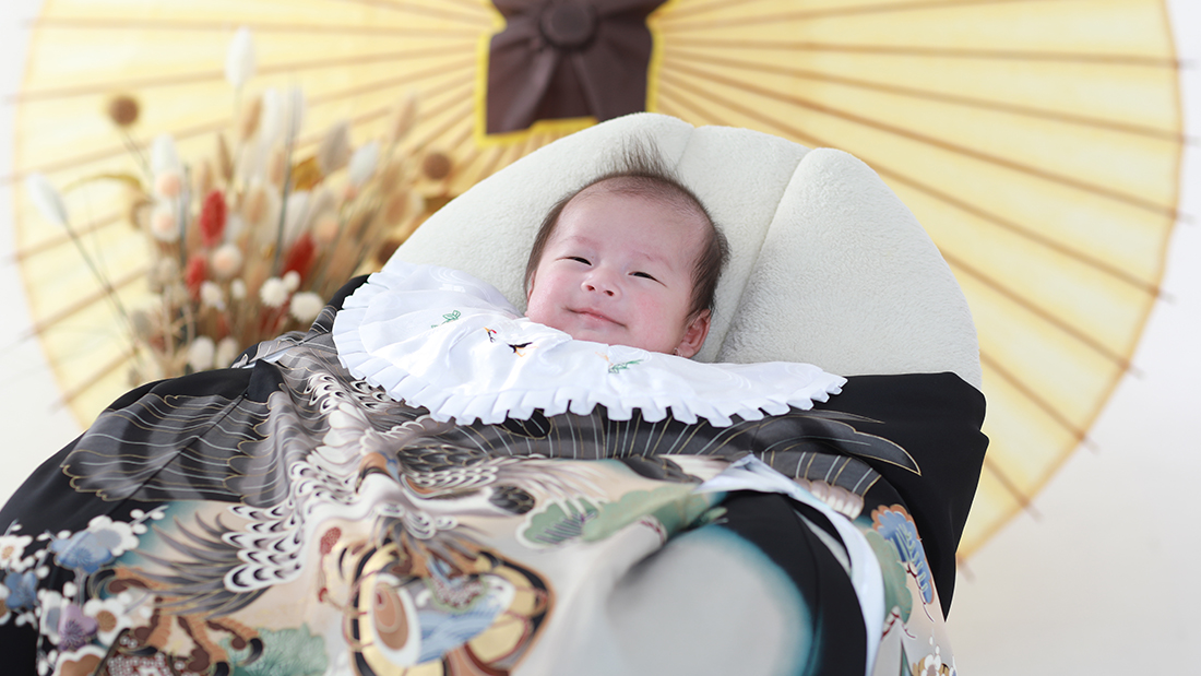 黒い祝い着を着る男の子の赤ちゃん